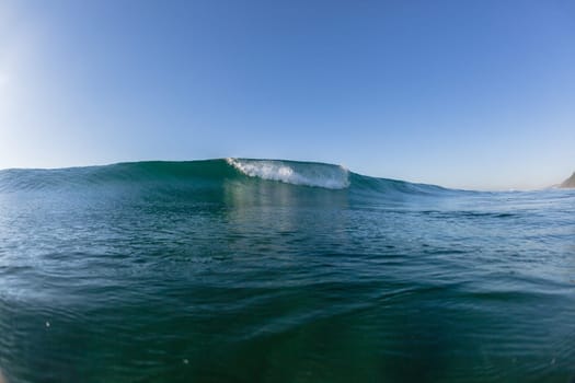 Ocean wave crashing water power energy on shallow reefs nearby beach coastline