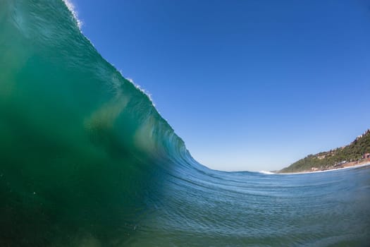 Ocean wave crashing water power energy on shallow reefs nearby beach coastline