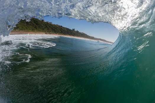 Ocean wave crashing water power energy on shallow reefs nearby beach coastline