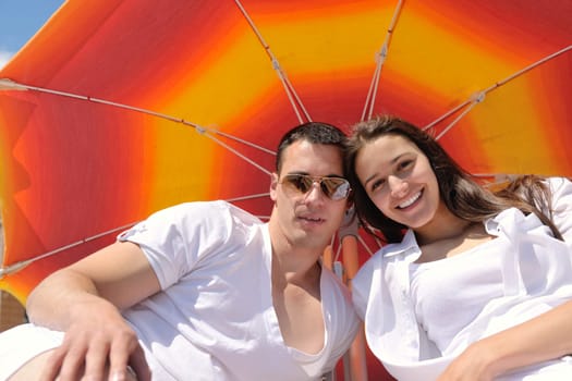 happy young couple have fun and relax  on the summer with heart drawing on beach sand