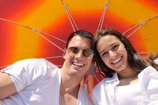 happy young couple have fun and relax  on the summer with heart drawing on beach sand