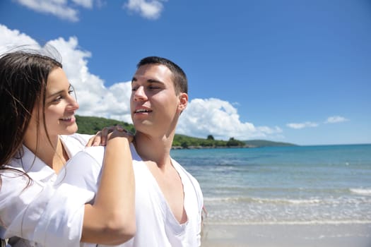 happy young couple have fun and relax  on the summer with heart drawing on beach sand