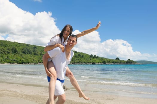 happy young couple have fun and relax  on the summer with heart drawing on beach sand