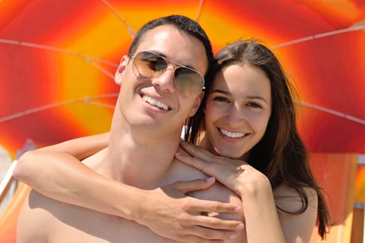 happy young couple have fun and relax  on the summer with heart drawing on beach sand