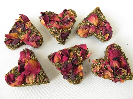 Tea brick with green tea and rose petals in heart shape