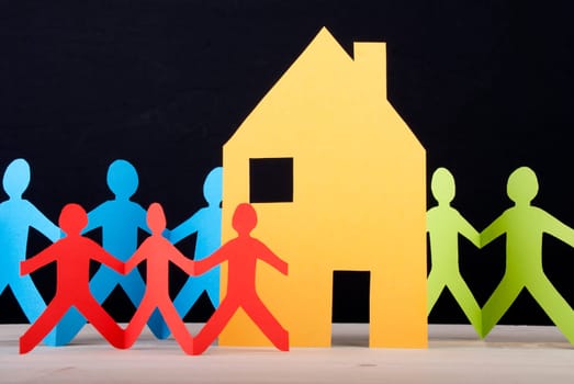 Many Colorful Paper Chain People around a House, Black Background