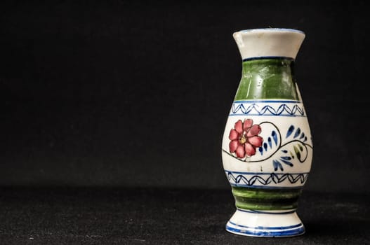Colorful designed clay vase over a Black background