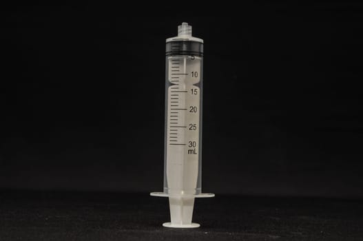 Black and White Syringe on a Dark Background