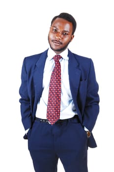 A young black business man standing in a blue suit and tie with his hands.in his pocket for white background..