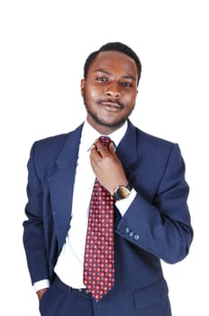 A young black business man standing in a blue suit and tie, fixing his tie.for white background..
