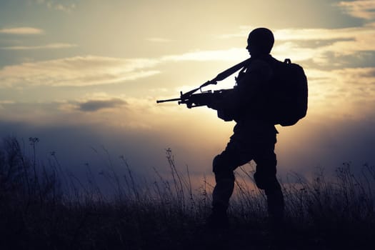 Silhouette of US marine with rifle against the sunset