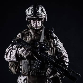 US marine with his assault rifle on black background