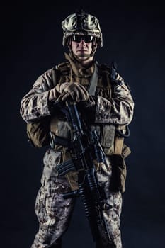 US marine with his assault rifle on black background