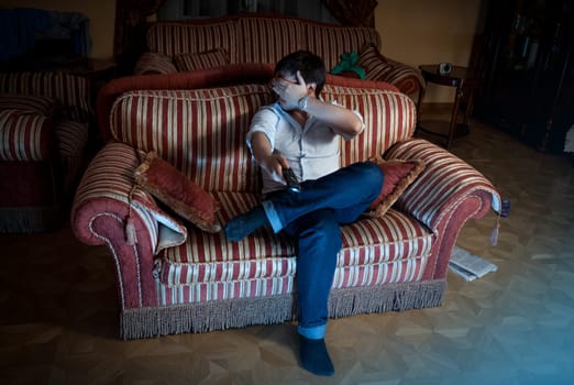 Young man closing eyes with hand while watching thriller at night