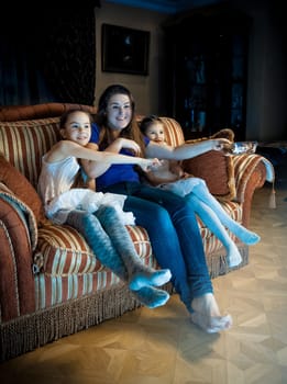 Photo of family with kids watching TV at late evening