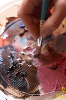 Color palette with oil paint and brush