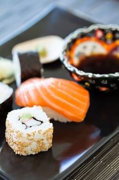Closeup of plate of healthy freshly prepared sushi with bowl soy sauce