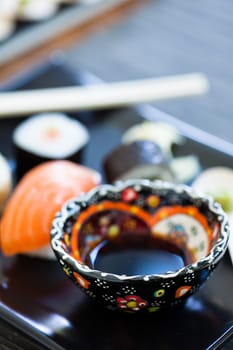 Closeup of bowl of soy sauce on sushi plate