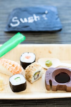 Closeup of plate of healthy freshly prepared sushi with decorative stone with text label