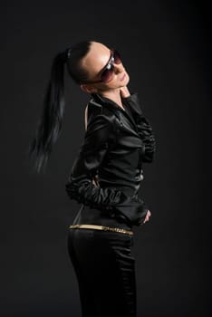 Profile shot of beautiful Caucasian woman wearing black bodysuit against black background