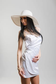 Portrait of beautiful Caucasian woman wearing short white dress and large white hat