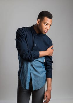 Portrait of handsome dark skinned male model wearing casual clothes against white background