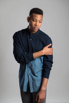 Portrait of handsome dark skinned male model wearing casual clothes against white background