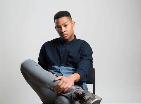 Portrait of handsome dark skinned male model wearing casual clothes against white background