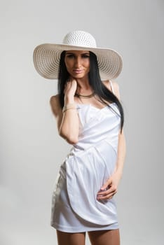Portrait of beautiful Caucasian woman wearing short white dress and large white hat