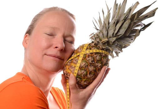 Smiling woman holding a pine apple with a measuring tape