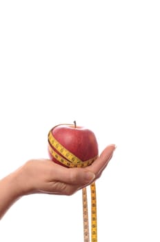 Female hand holding an apple with a measuring tape,diet concept