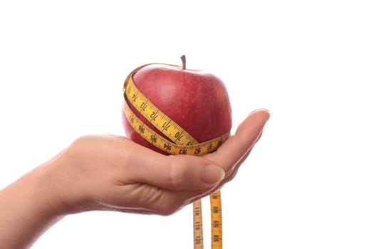 Female hand holding an apple with a measuring tape,diet concept