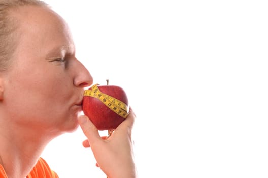 Woman kissing an apple with a measuring tape