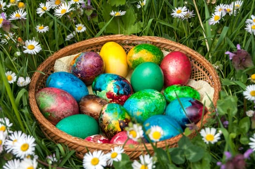 Patterned Easter eggs amidst spring field of daisies