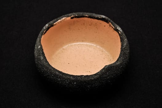 Colorful designed clay vase over a Black background