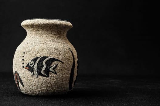 Colorful designed clay vase over a Black background