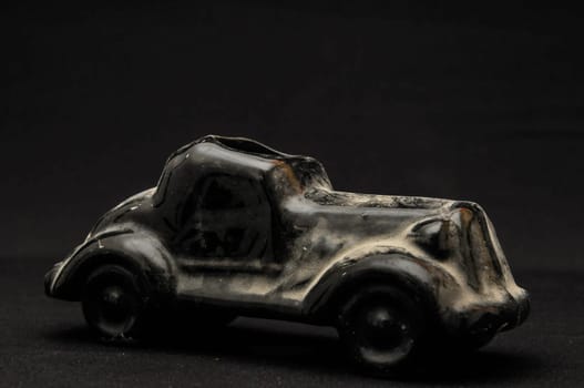 Vintage Old Ceramic Black Car on the Dark background