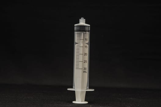 Black and White Syringe on a Dark Background