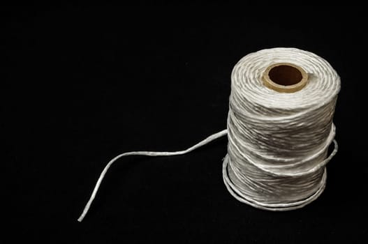 Roll of White Twine on a Black Background
