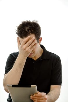 Portrait of a unhappy young man with tablet pc against white background