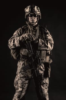 US marine with his assault rifle on black background