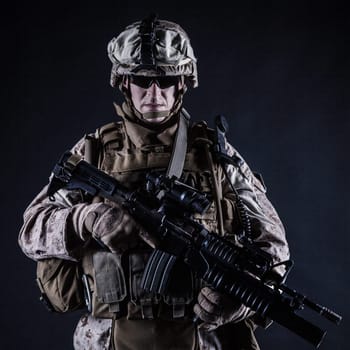 US marine with his assault rifle on black background