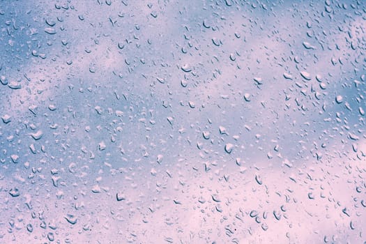 Water drops on window glass, blurred on the edges. Image processing with color filter effects