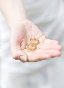 Wedding rings inside the hand of a bride