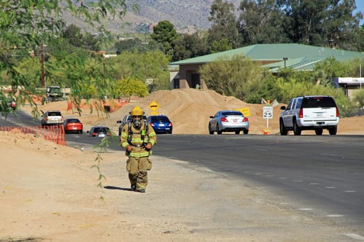 TUCSON, ARIZONA, USA --April 21, 2014:  A Firefighter who is training by running alongside the road with his protective suit and air pack on in Arizona.