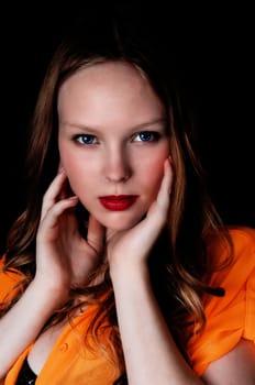 A closeup portrait picture of a lovely teenage girl with blue eye's, holding.her face, isolated for black background..
