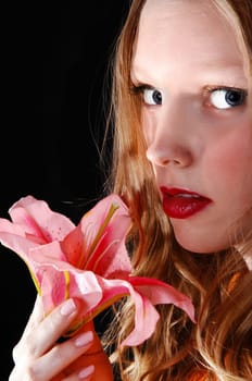 A lovely closeup picture of a young woman holding a pink lily,.isolated for black background..