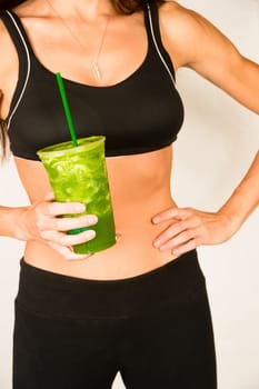 Woman holds Green Fruit Smoothie Waist Level Showing Healthy Slender Body