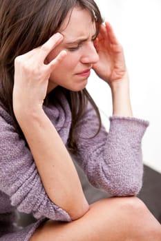 young woman rubbing against her temples because she has a bad headache