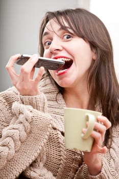 funny woman pretending to eat a mobile phone with her tea